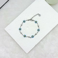 Detail of 18k gold stainless steel bracelet with blue daisies and small stars - Blue Silver