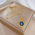 Nahaufnahme des goldenen Evil Eye Anhängers mit blauen Kristallen auf Schmuckdose - Böser Blick Mikro-Inlaid Anhänger Halskette (E133)