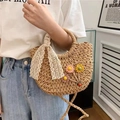 Detail der Strohhandtasche mit floralen Akzenten und einer weißen Spitzenschleife - Marienkäfer-Braun
