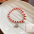 Detail of beaded bracelet featuring ceramic crystals and a polished silver cherry charm - Red and White Cherry Style