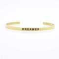 Minimalist 4mm gold stainless steel cuff bracelet featuring a black DREAMER engraving - DREAMER