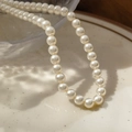 Elegant 2mm white crystal pearl necklace with a lustrous round finish on a ceramic plate - 6mm White