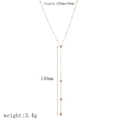 Detailansicht der goldenen Y-Halskette aus Edelstahl mit Größen- und Gewichtsangaben - Feine Kette Kugel Quaste Design (TN3521)