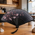 Classic black folding fan featuring pink cherry blossoms and a decorative tassel - Black Sakura Butterfly