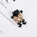 Retro frog brooch in black alloy with gold bowtie and green eyes on a vintage magazine - Black Gold Bowtie Frog (#1)