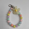 Detail von bunten transparenten Bonbon-Perlen und gelbem Blumenanhänger mit Metallverschluss - Mehrfarbige Perlen Gelbe Blume