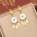 Detail of gold evil eye earrings with blue enamel and white shell on jewelry display pad - 4# Eye Earrings