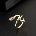 Close-up of golden snake ring with colorful zircons on a dark textured surface - Colorful Pavé Gold Snake Open Ring