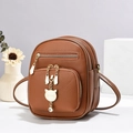 Brauner Mini-Rucksack mit Lychee-Lederstruktur und weißem Katzenanhänger für Damen - Erdgelb
