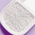 Close-up of pearl white peanut-shaped acrylic beads for DIY jewelry making accessories - White