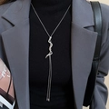 Detail of silver snake pendant necklace with diamonds on black sweater and grey blazer - Silver Rhinestone Snake Necklace