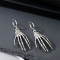 Gothische punk skelet hand oorbellen in vintage zilver metaal op een donkere achtergrond - Skelet hand oorbellen