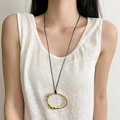 Détail du collier à pendentif doré irrégulier minimaliste avec texture martelée - Doré