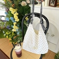 Borsa tote in tela a pois bianchi con tracolla a scacchi neri e bianchi sulla sedia - Borsa con spalline annodabili