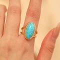 Anillo vintage dorado con turquesa y banda triple trenzada bohemia en la mano del modelo - Estilo Resina Azul / Oro KC