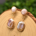 Handcrafted pink baroque pearl drop earrings with gold wire wrap on a wooden stump - Purple Baroque