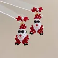Detail of handmade beaded Santa Claus earrings with a red matte bow and faux pearl accent - Bow Santa Claus-Silver Pin / Stud Earrings