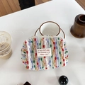 Colorful knitted makeup bag with vibrant stripes and secure zipper on a desk - Colorful