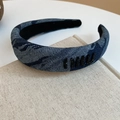 Close-up of blue denim headband featuring black sequin embroidered logo on fabric - Navy Blue Letter Style