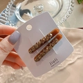 Close-up of amber hair clips with champagne rhinestones on a decorative display card - Full Rhinestone Brown Pair