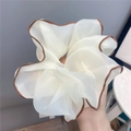 Makro-Detail eines großen weißen Chiffon-Haargummis mit eleganter brauner Paspelkante - Braune Paspelierung / Gebrochenes Weiß