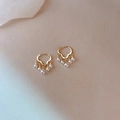 Elegant gold wavy hoop earrings with five hanging white pearls on a beige textured base - Cloud Pearl Buckle
