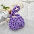 Handmade purple chunky knit handbag with round braided handle on a white fabric background - Purple