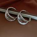 Macro shot of silver plated C-shaped hoop earrings with a twisted minimalist design - 17# Silver Irregular Wide C-Shape Earring