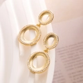 Detail of gold-plated oval hoop earrings with sparkling cubic zirconia on a white pedestal - Gold Double Oval Style
