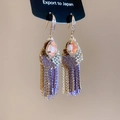 Vista de detalle de pendientes de borla morados con gema rosa de gota y detalles dorados - 34# Gancho de Oreja Color Dorado Púrpura