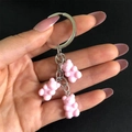 Detailed view of pink resin cartoon bear pendants on a sturdy metal keychain link - Light Pink