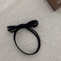Minimalist black bow hair tie elastic band on beige linen background for women - Black