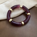 Dettaglio del bracciale con tubi in acrilico viola cangiante e perle distanziatrici dorate - Viola (Motivo Marmo)