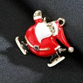 Detalle de un broche de Papá Noel patinando en esmalte rojo con baño de oro y cristales - Papá Noel Dorado