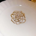 Dettaglio ravvicinato di una spilla a rosa dorata con cristalli su un piatto bianco - Rosa Dorata (10#)