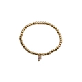 Close-up of gold beaded stretch bracelet featuring a colorful pave zircon letter F charm - Letter F