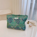 Detalle de tela jacquard floral verde en neceser con texturas tejidas de estilo retro - Peonía de Meandro