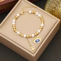 Gold- und Perlenarmband mit Kronen-Auge und Hamsa-Anhängern in einer Geschenkbox - Armband