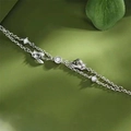 Elegante pulsera de muérdago de plata con circonitas y colgante de lazo sobre verde - Estilo de Mujer