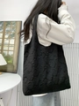 Detail view of the black embossed floral texture on this elegant shoulder tote bag - Black