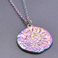 Macro shot of iridescent stainless steel sun and moon relief pendant necklace - Rainbow Color Necklace