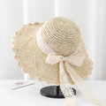 Detail of beige straw sun hat with white lace trim and bow knot on a display stand - V-Hollow Lace Bow / Beige