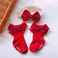 Detail of red baby socks with anti-slip grip and matching lace velvet bow headband set - Red Corduroy Bow Set