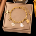 Gold stainless steel ocean bracelet with pearl, starfish, and shell charms on jewelry box - Gold Starfish Shell Zirconia Bracelet (SLE178)