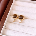 Close-up of vintage gold earrings with round tiger eye stone and diamond detail - Round Style With Rhinestone