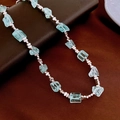 Détail macro des pierres d'aigue-marine et perles en métal rose sur fond de cuir - 14# Collier - Argent Bleu Cristal
