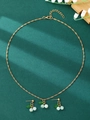 Set gioielli ciliegia dorati con perle turchesi e foglie verdi su sfondo verde scuro - Collezione Gioielli Ciliegia con Perline Verde Chiaro (N-446)