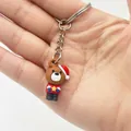 Close-up of mini Christmas bear keychain with red star sweater and festive hat - Christmas Bear Style