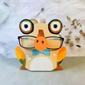 Creative wooden animal glasses holder with a blue polka dot bowtie on a desk - Yellow Frog