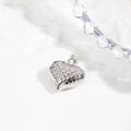 Macro shot of silver hollow heart pendant with quilted texture on white ceramic plate - 24*20mm Quilted Heart Pendant / Silver